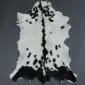 Natural goatskin rug with white fur, black spots, and a dark stripe down the centre.