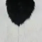 Natural goatskin rug with long black and white fur in a patterned hide shape.