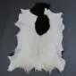 Natural goatskin rug with white fur and a large black patch at the top, featuring irregular edges.