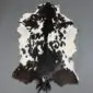 Natural goatskin rug with irregular black and dark brown patches on a white background.