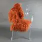 Burnt orange Mongolian lambskin rug with long curly wool laid flat.