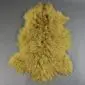Mustard yellow Mongolian lambskin rug with long, curly wool fibres and a natural hide shape.