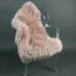 Long-pile dusty pink sheepskin rug laid flat.