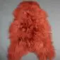Terracotta orange Icelandic sheepskin rug with long, shaggy wool and a natural hide shape.