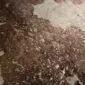 Brown and White Gold Metallic Cowhide Rug CM283 (1) Close-up of a brown and white cowhide rug with rose gold metallic splatters. detail view