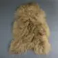 Long-haired Icelandic sheepskin rug in camel brown with a natural, irregular shape.