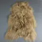 Long-haired Icelandic sheepskin rug in camel brown with a natural, shaggy texture.