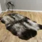 Large four-skin rare breed sheepskin rug with natural grey, cream and dark brown mottled wool on a wooden floor.