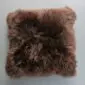Square natural brown sheepskin cushion with long, textured wool pile.