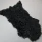 Black Tibetan lambskin rug with long, curly wool fibres and an irregular natural shape.