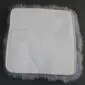 Underside of a square steel grey sheepskin seat pad with a light grey fabric backing and stitched border.