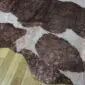 Natural brown and white cowhide rug with metallic rose gold speckled finish.
