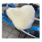 Ivory sheepskin bicycle seat cover with a thick, fluffy texture fitted onto a bike saddle.