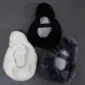 Underside of white, black and grey sheepskin bicycle seat covers showing elasticated edges and fabric backing.