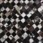 Patchwork cowhide rug featuring a diamond pattern of black, brown, and speckled white squares.