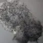 Natural grey curly sheepskin rug with textured wool locks.