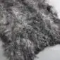Grey Curly Gotland Sheepskin Rug GOT246 (3) Close-up of a natural grey sheepskin rug featuring dense, curly wool fibres in variegated shades of charcoal and silver.