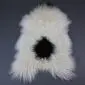 Natural white curly Icelandic sheepskin rug with a large black spot in the centre.