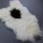Natural white curly Icelandic sheepskin rug with a large black spot in the centre. detail view