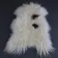 Natural white curly Icelandic sheepskin rug with two distinct dark brown spots and long textured wool.