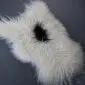 Natural white Icelandic sheepskin rug with long curly wool and a single black spot in the centre.