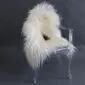 Long-haired cream Icelandic sheepskin rug with natural dark spots laid flat.