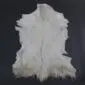 Natural white goatskin rug with grey and tan markings and an irregular organic shape.