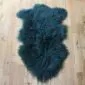 Curly Mongolian Sheepskin Rug Jungle Greena Jungle green Mongolian lambskin rug with long, curly wool fibres and a natural hide shape. detail view