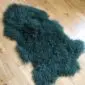 Curly Mongolian Sheepskin Rug Jungle Greenb Jungle green Mongolian lambskin rug with long, curly wool fibres and a natural hide shape. detail view detail view