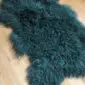 Curly Mongolian Sheepskin Rug Jungle Greenc Long-haired, curly Mongolian lambskin rug in jungle green with a natural hide shape.