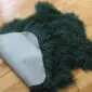 Curly Mongolian Sheepskin Rug Jungle Greend Jungle green Mongolian lambskin rug with long curly wool and a light grey suede underside.