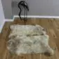 Large rare breed double sheepskin rug with natural cream, grey and brown mottled wool on a wooden floor.
