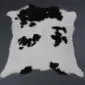 Natural calfskin rug with a white base and irregular black patches.
