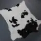 Natural calfskin rug with a white base and irregular black patches. detail view