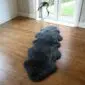 Sheepskin-Double-Grey Long, dark grey double sheepskin rug with a thick, textured wool pile on a wooden floor.
