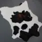 Natural calfskin rug with a white base and large black and dark brown patches.
