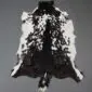 Natural goatskin rug with a speckled black and white pattern and irregular edges.