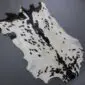 Natural goatskin rug with white fur and irregular black spots and markings.