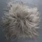 Square taupe Icelandic sheepskin seat pad with long, shaggy wool fibres.