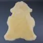 Natural yellow medical sheepskin rug with a dense, short pile and organic hide shape.