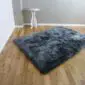 P1470542 Large rectangular sheepskin rug in dark grey with a thick, textured pile on a wooden floor.
