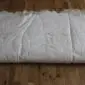 Large rectangular eight-skin rare breed sheepskin rug in cream and grey tones on a wooden floor.