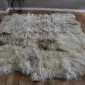 Large eight-skin rare breed sheepskin rug with long, textured wool in cream, grey, and brown tones.