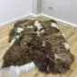 IMG_3335 Long-haired Icelandic sheepskin rug with rusty brown and white spotted markings on a wooden floor.