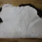 IMG_3346 The underside of an Icelandic sheepskin rug showing the white leather backing and dark brown wool edges.
