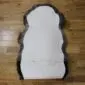 The underside of a double rare breed sheepskin rug showing the white leather backing and stitched seam.