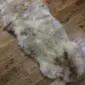 Long double sheepskin rug with thick cream and grey wool pile.