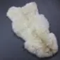 Rare Breed Sheepskin Rug RBS122c Natural cream rare breed sheepskin rug with thick, curly wool and an irregular organic shape.