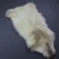 Natural cream rare breed sheepskin rug with long, textured wool and organic edges.