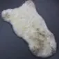 Rare Breed Sheepskin Rug RBS126c Natural cream sheepskin rug with grey and brown mottled markings and a thick, textured wool pile.